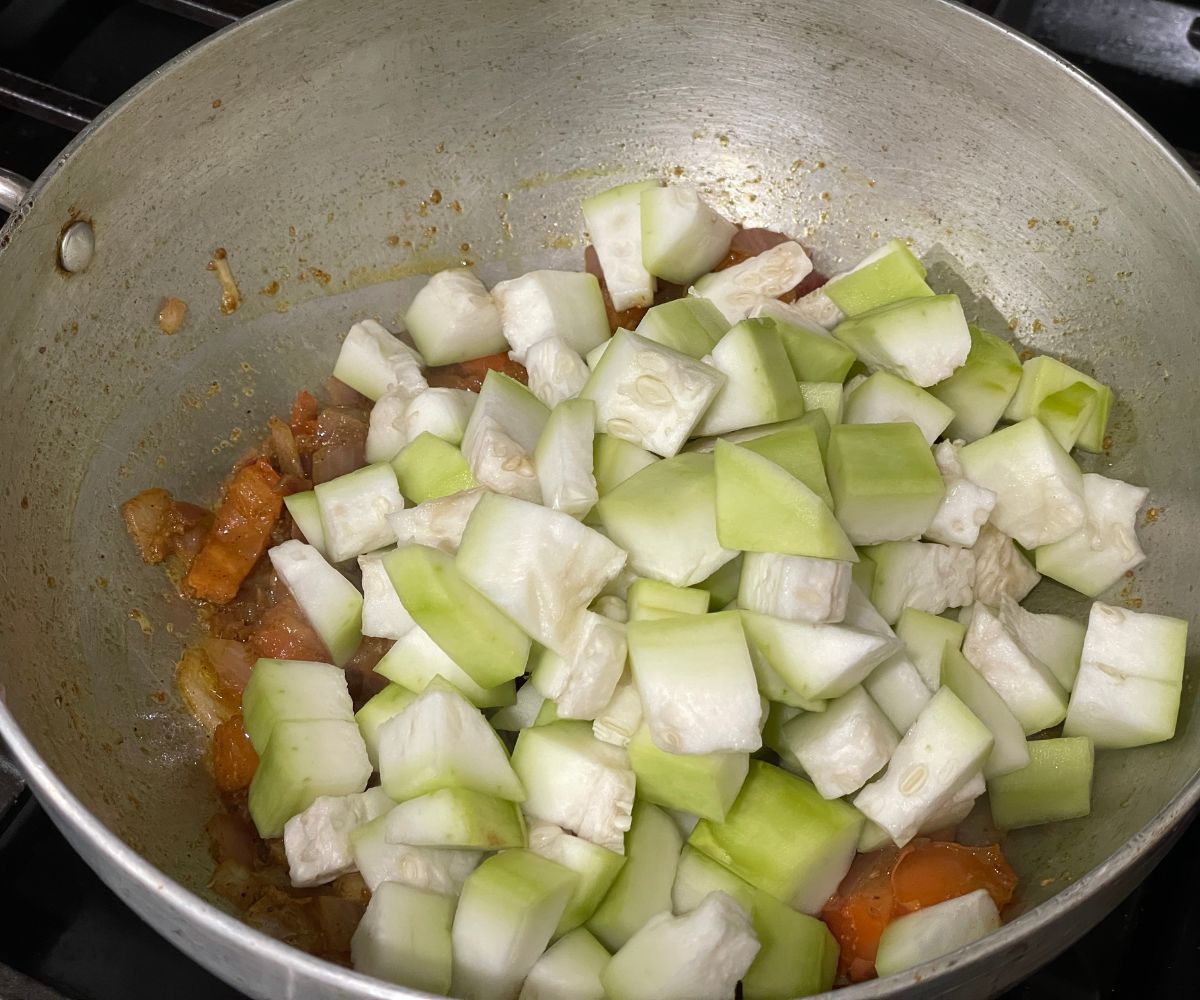 A pot is with spices and bottle gourd over the heat.