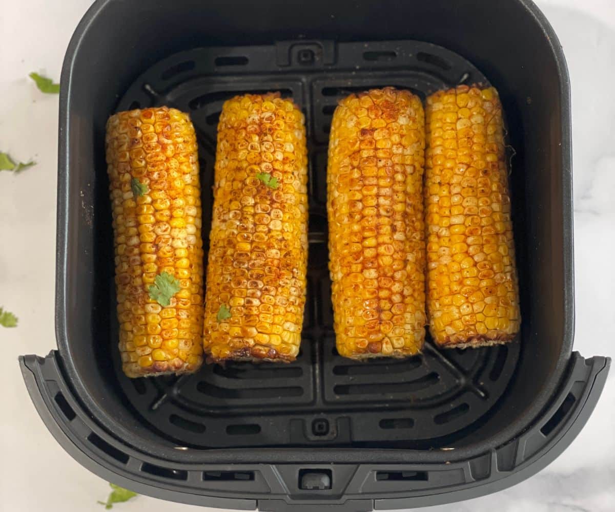 Air basket is with roasted corn on the cob.