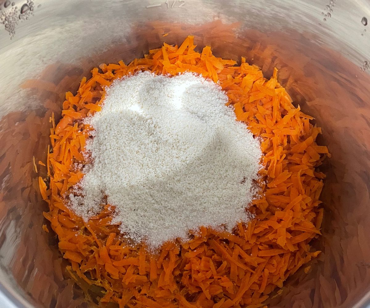 An instant pot is with carrots, sugar, and almond meal on saute mode.