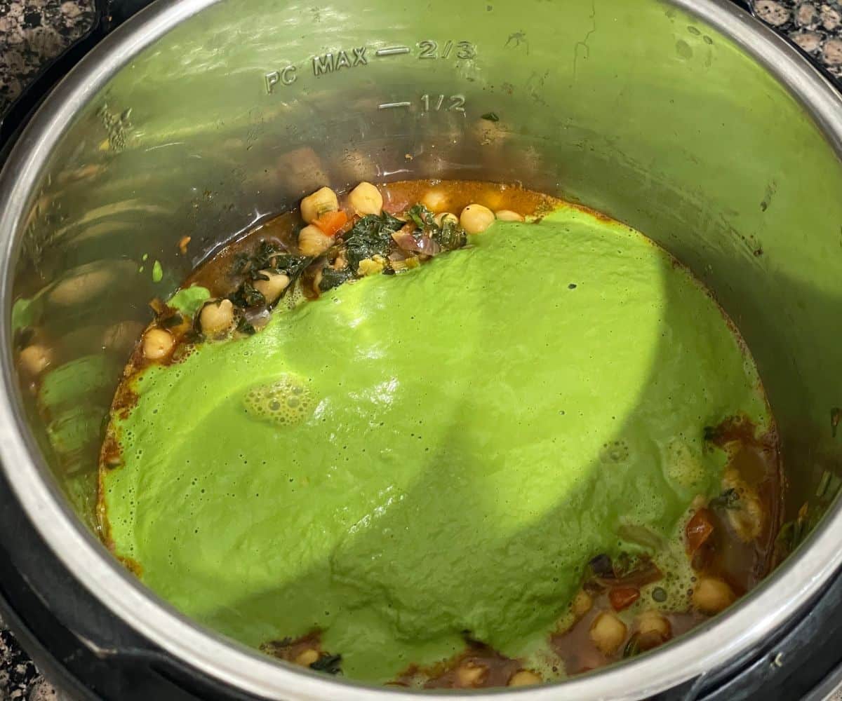 An Instant pot is filled with spinach chickpea curry.