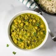 A bowl of chana palak curry is on the surface.