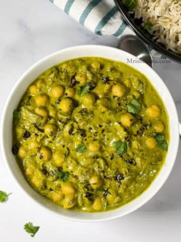 A bowl of chana palak curry is on the surface.