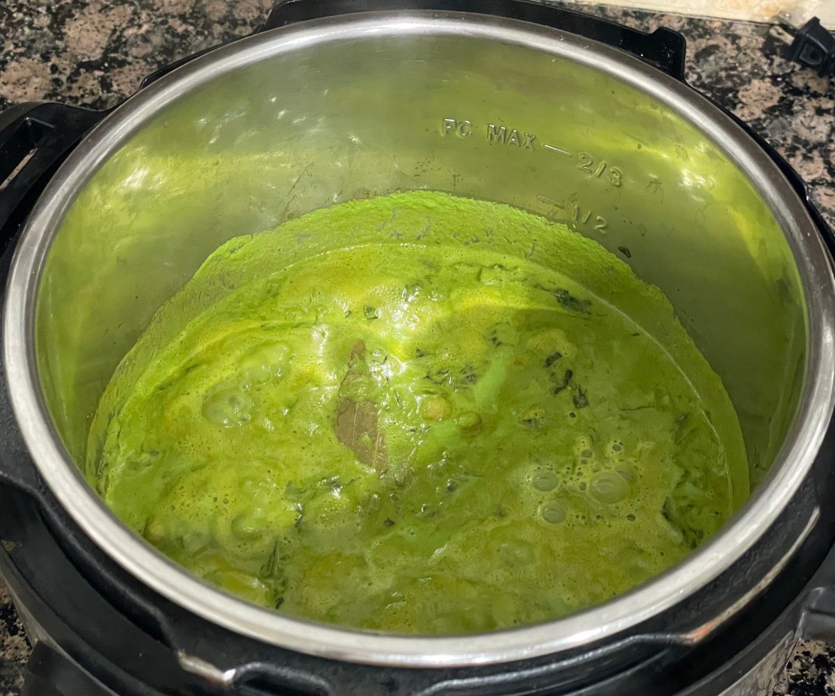 A pot of chana palak curry is on the counter top.