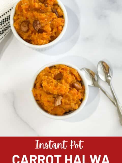 A bowl of carrot halwa is on the table with two spoons.