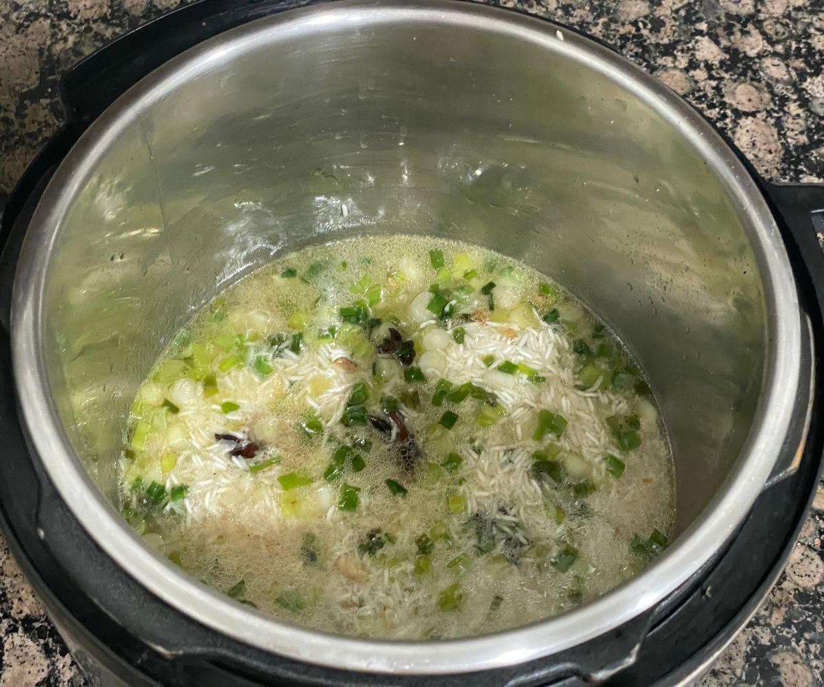 A pot is with a green onion rice mixture.