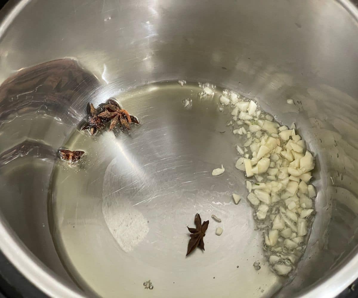 An instant pot is with oil. chopped garlic on saute mode.