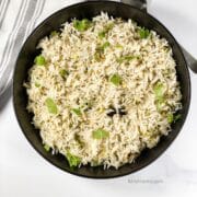 A plate is filled with green onion rice.