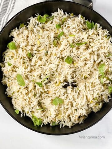 A plate is filled with green onion rice.