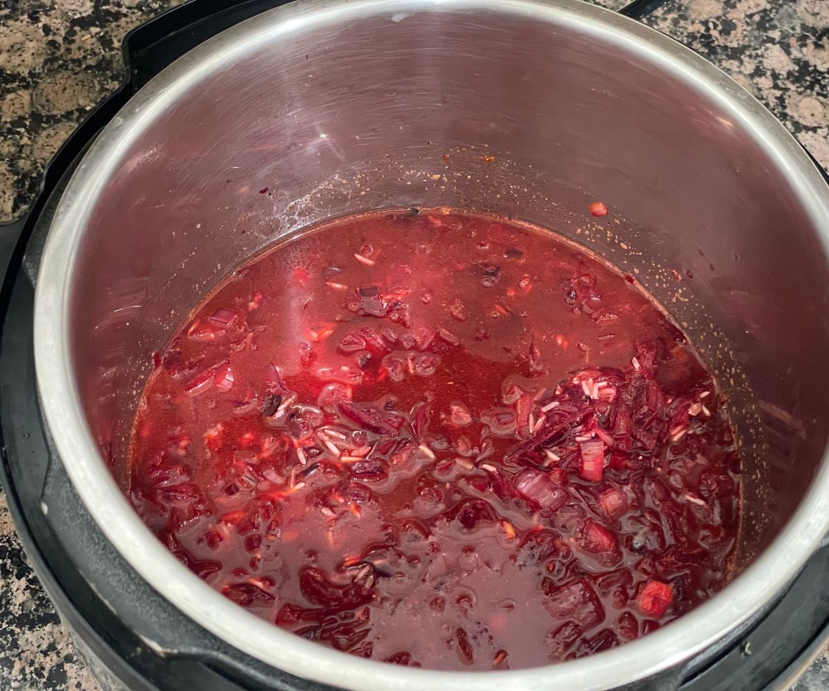 A pot with uncooked beet pulao mixture.