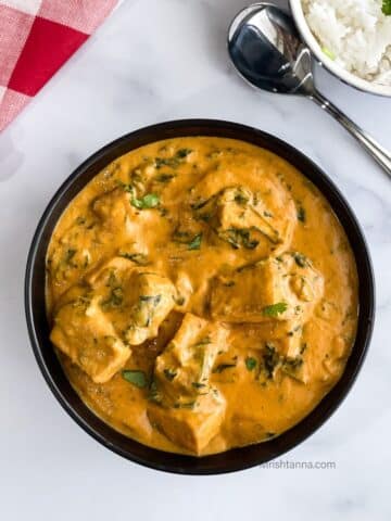 A bowl is with tofu spinach curry.