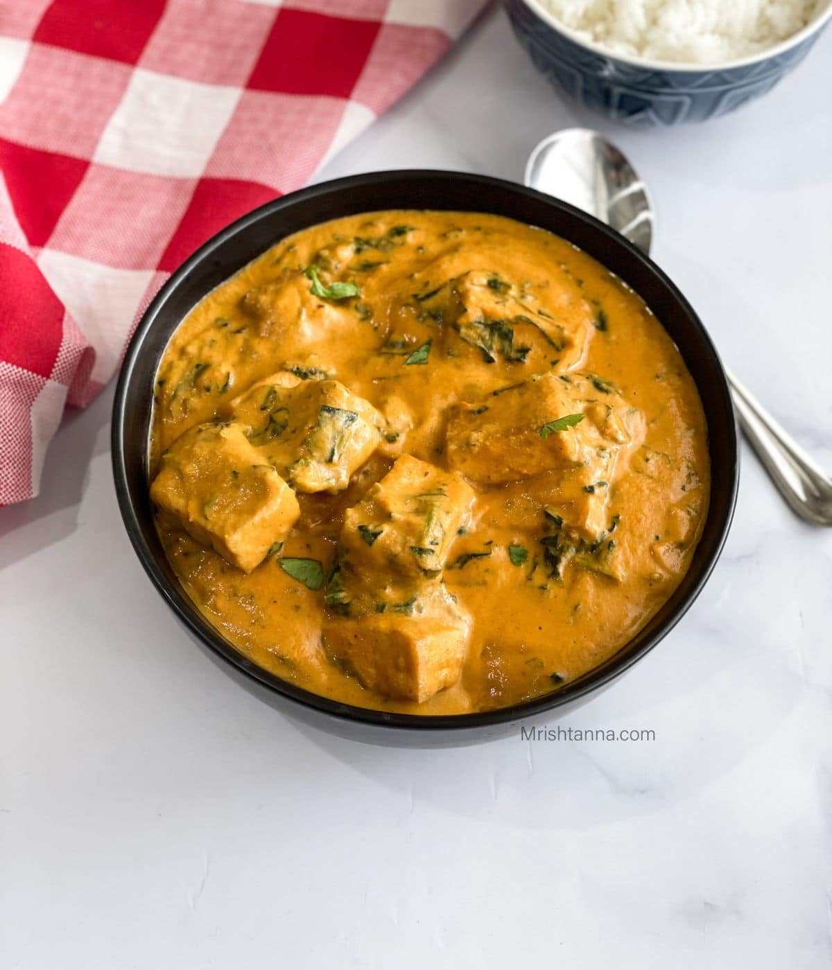 A bowl of tofu curry is on the table.