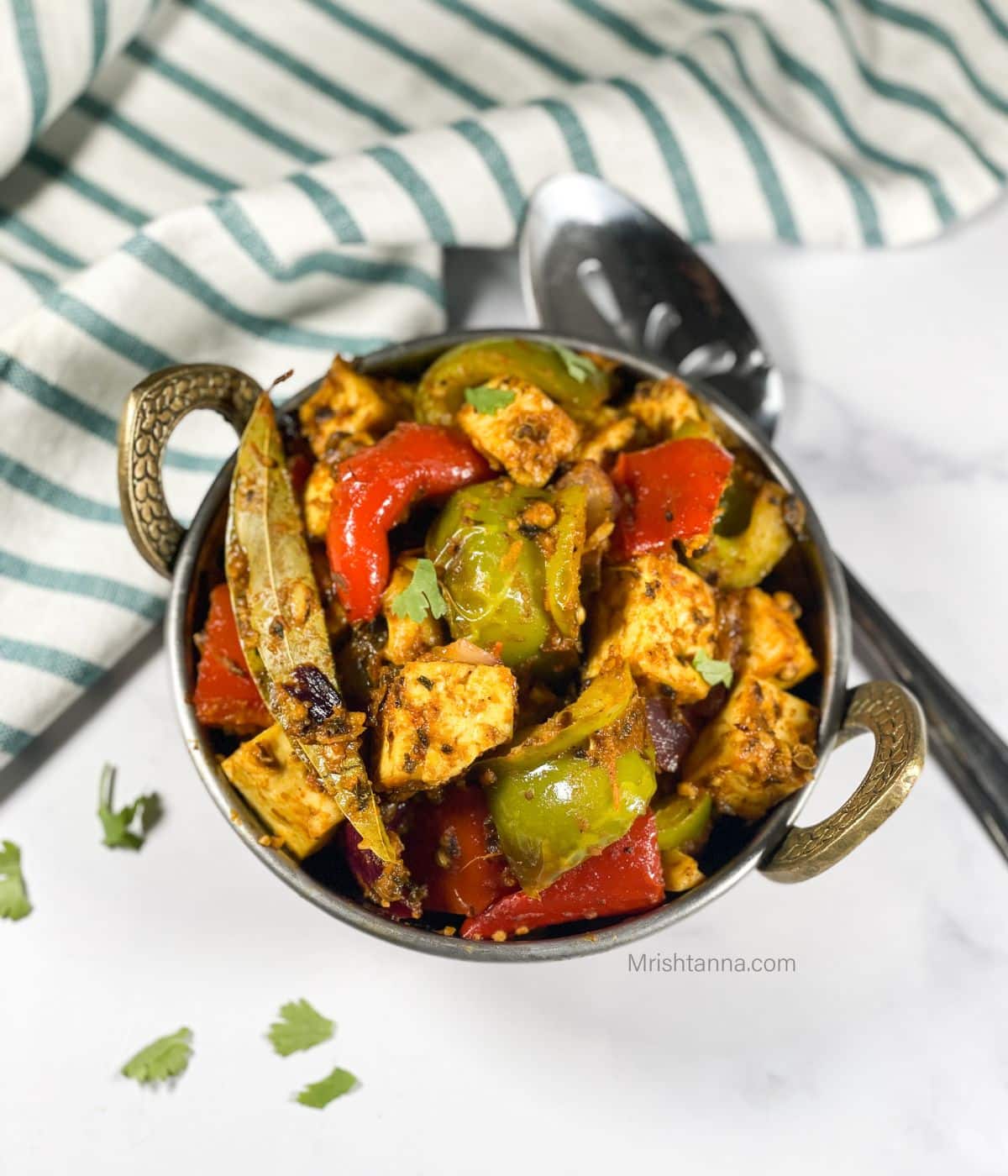 A small copper bowl is with  tofu kadai stir fry.