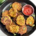Air fryer Zucchini fritters are on the plate with ketchup.