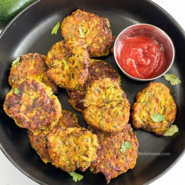 Air fryer Zucchini fritters are on the plate with ketchup.