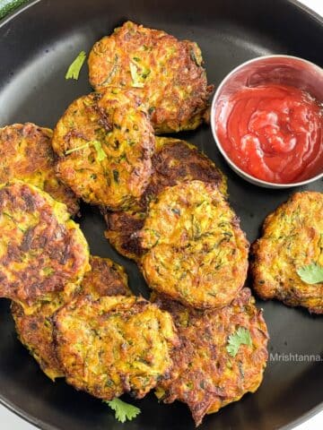 Air fryer Zucchini fritters are on the plate with ketchup.