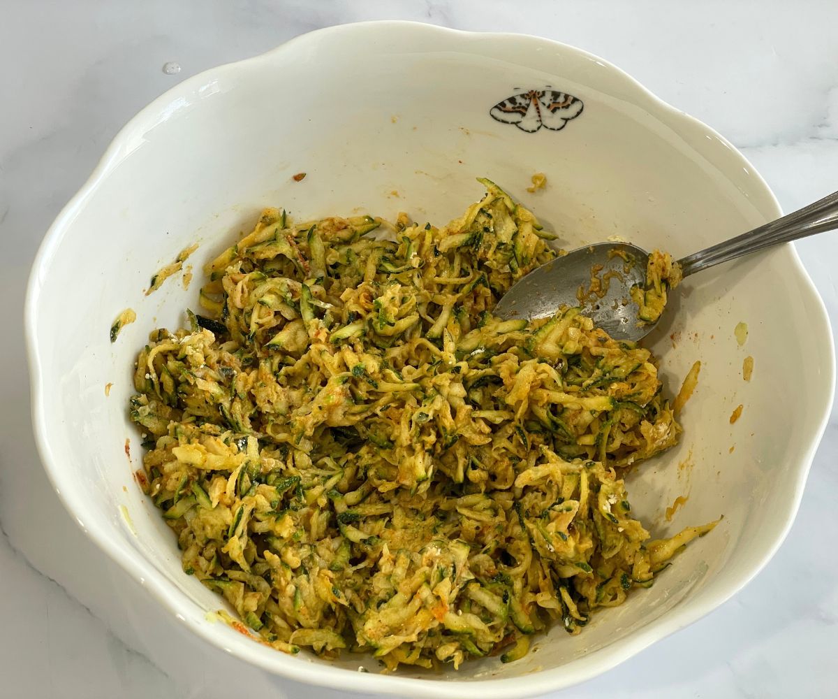 A bowl is with zucchini fritter batter.