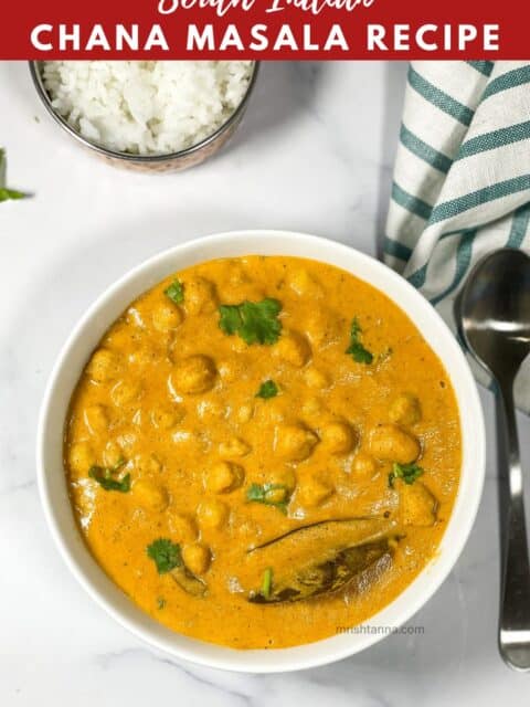 A bow of South Indian chana masala curry is on the surface with rice bowl.