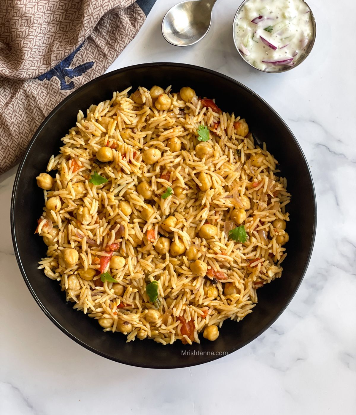 A plate of chana pulao is on the table.