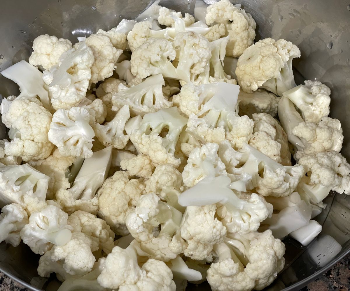 A pot is with hot water and cauliflower florets.