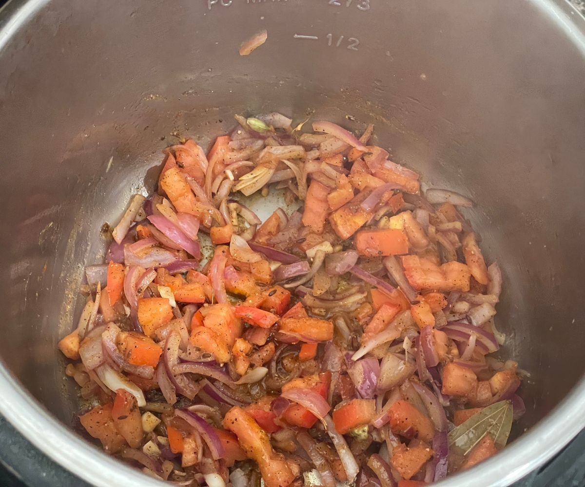 An instant pot is with spices and veggies for the chana pulao.