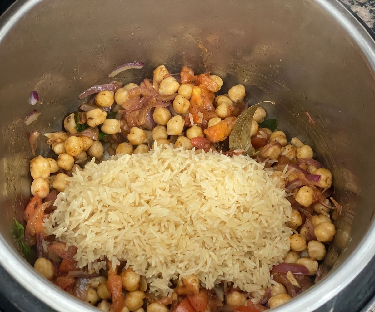A pot is with chana pulao mixture and rice.