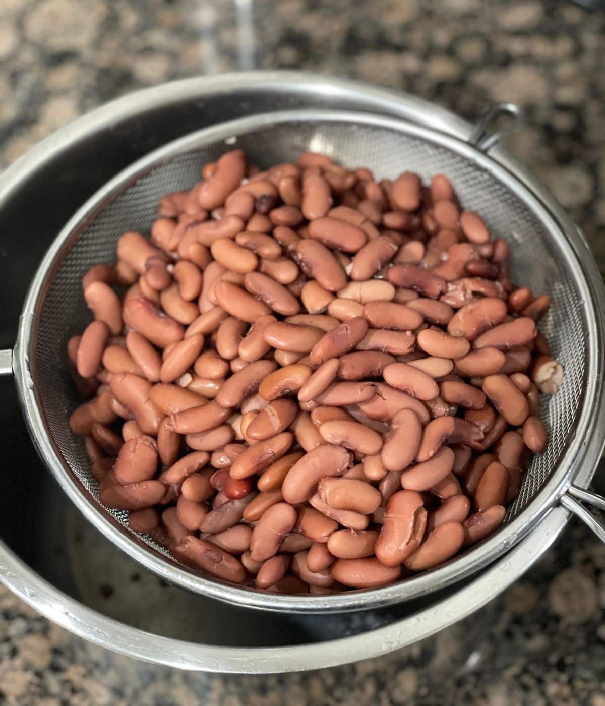 A strainer is filled with Instant pot kidney beans.