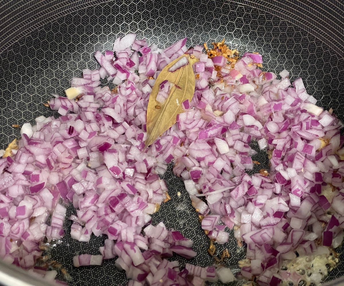 A pa is with chopped onions, ginger and garlic over the heat.