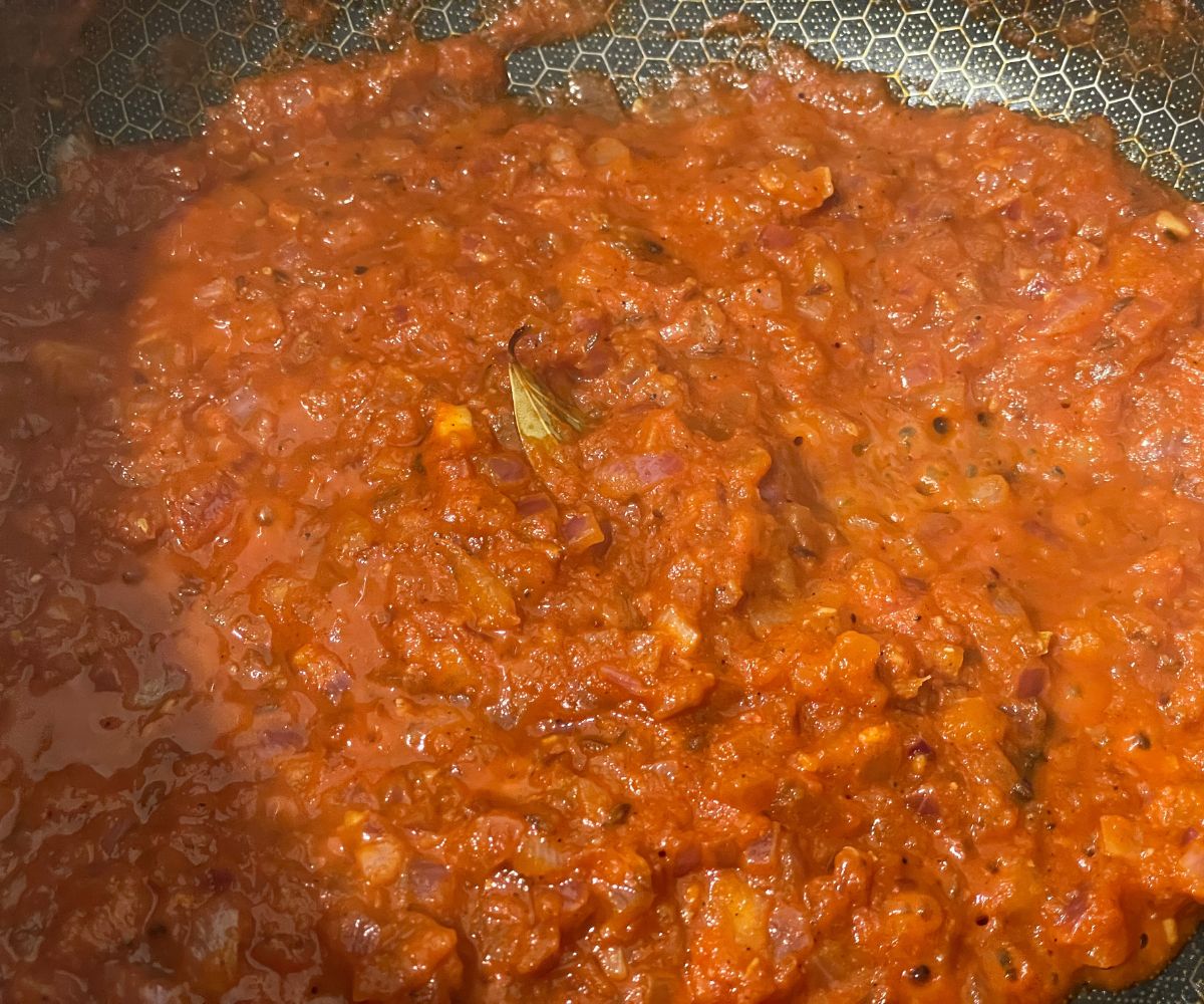 A pan is with rajma masala over the heat.