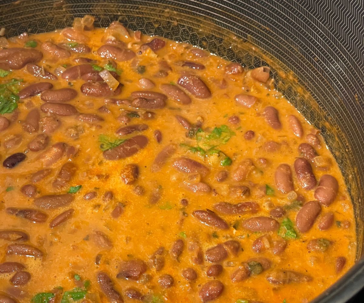 A pot of Kashmiri Rajma curry is on the table.