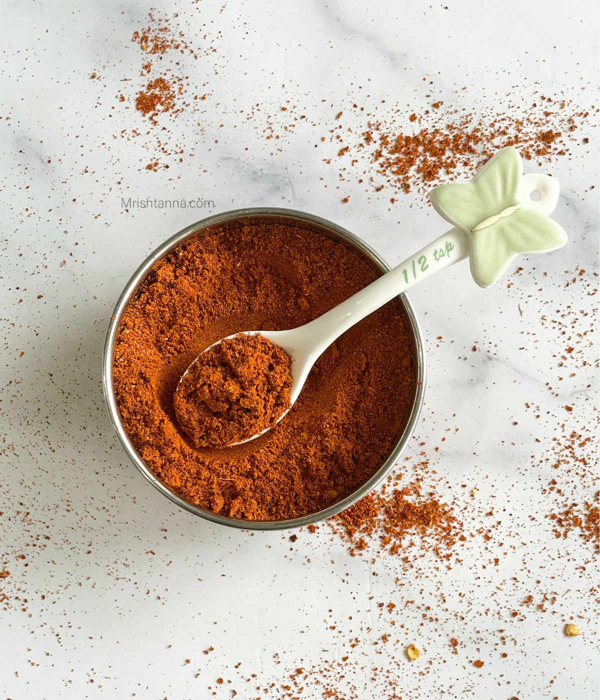 A small bowl is filled with madras curry powder.