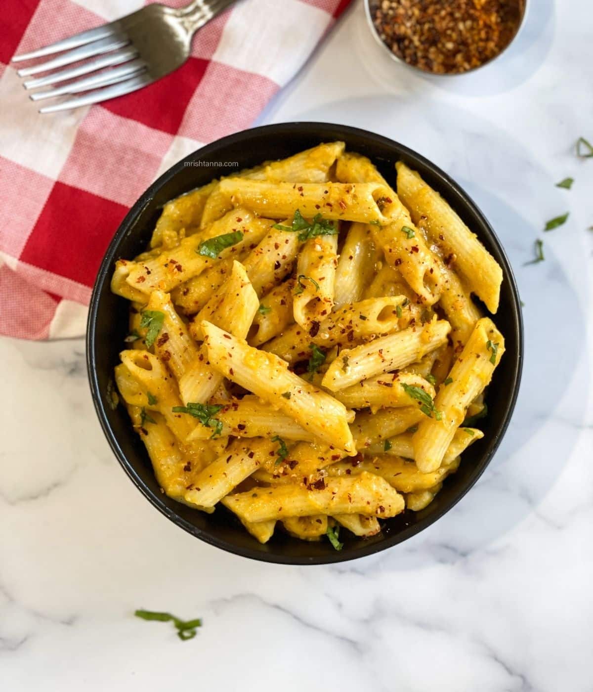 Pumpkin pasta sauce is in the bowl and topped with chili flakes.