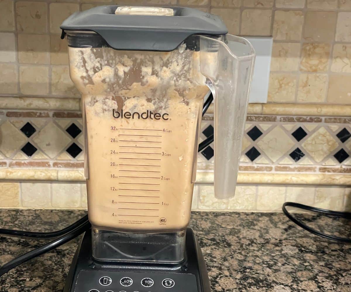 A blender is blending chana masala sauce.