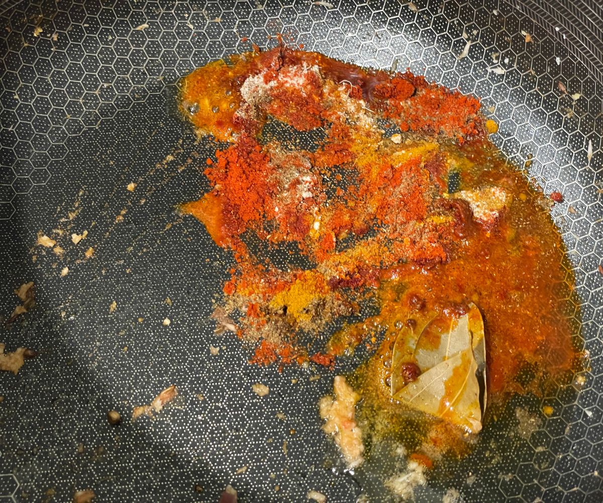 A pan is with oil and spice powders.