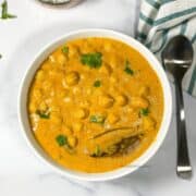 A bowl of South Indian chana masala is on the table.