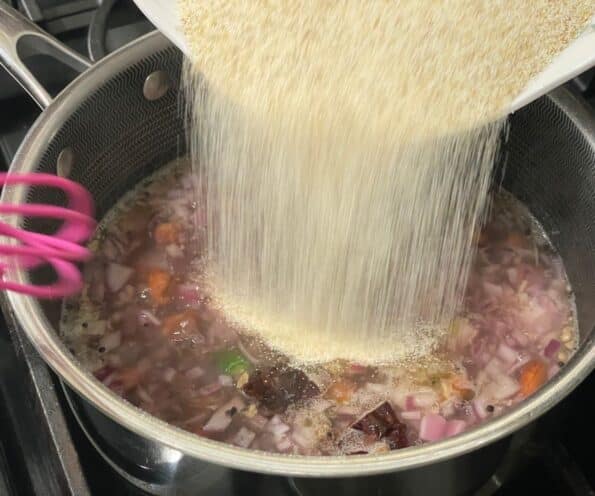 Roasted rava is pouring over the boiling water.