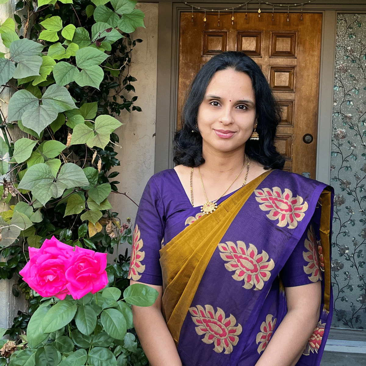 A women is standing near plants.