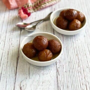Two bowls are filled with Vegan Gulab Jamuns.