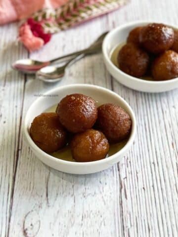 Two bowls are filled with Vegan Gulab Jamuns.