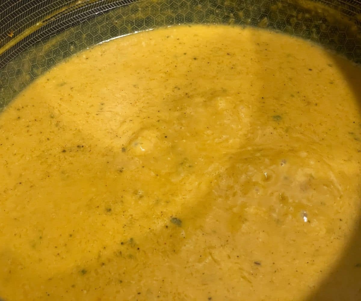 A saucepan is filled with creamy vegan pumpkin pasta sauce.