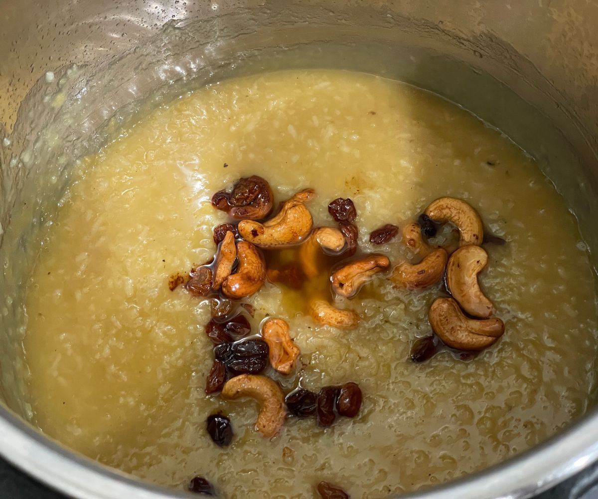 A pot of sweet pongal is topped with roasted nuts and fruits.