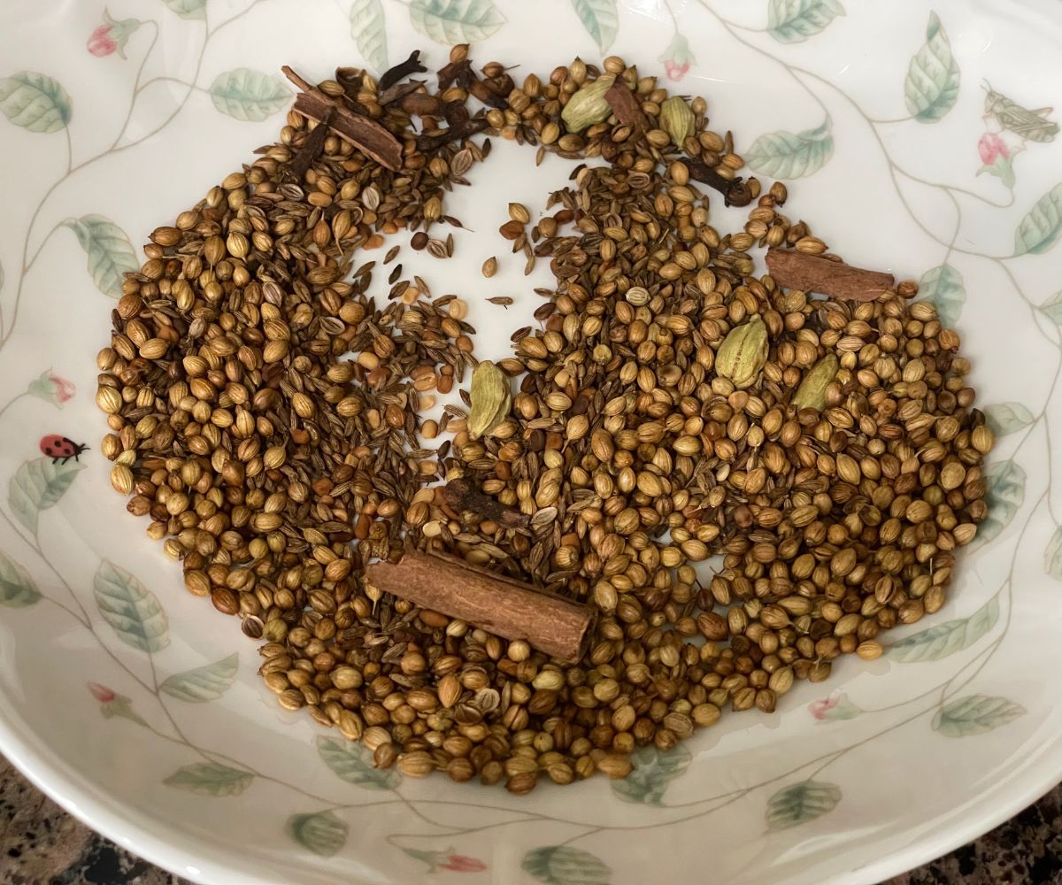 A plate of roasted spices is on the counter top.