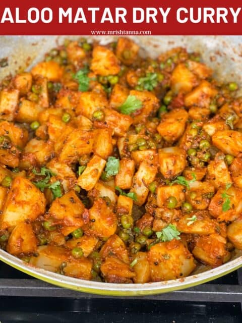 A pan is filled with curried potatoes and peas.