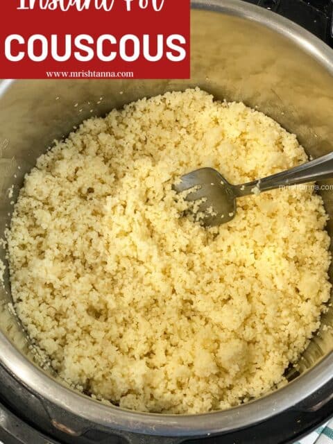 Cooked couscous is in the Instant pot with a fork.