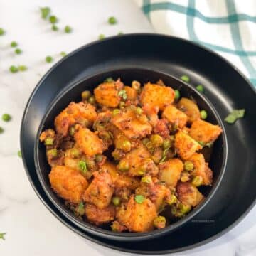 A bowl of aloo matar sabzi is on the plate.