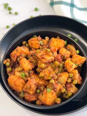 A bowl of aloo matar sabzi is on the plate.