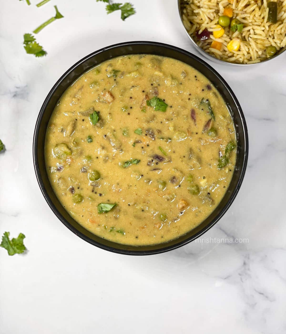 A bowl of Avarekalu sagu is on the surface.