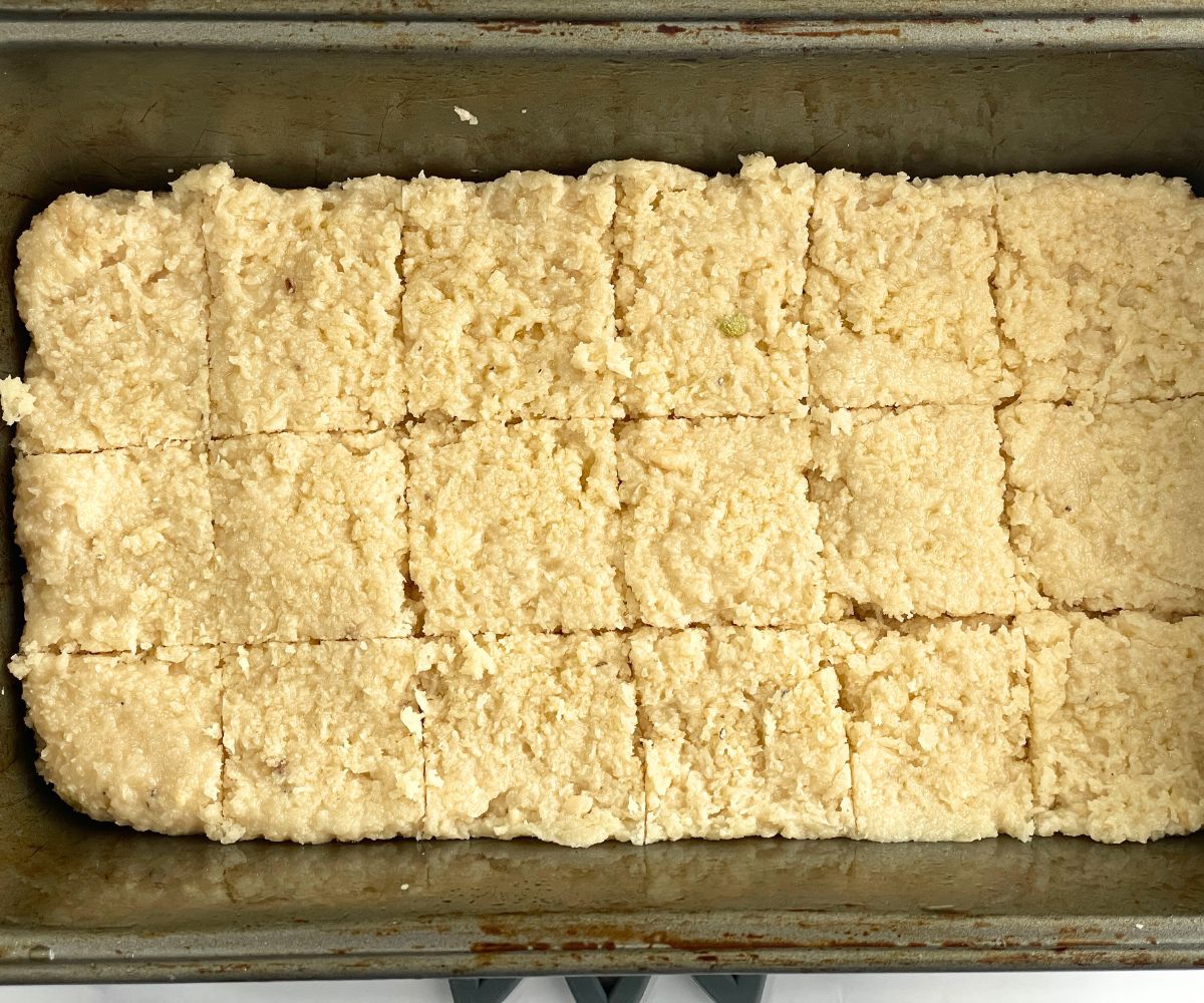 Coconut burfi shaped into square pieces.