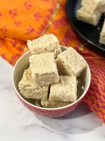 A bowl of Nariyal barfi is on the surface.