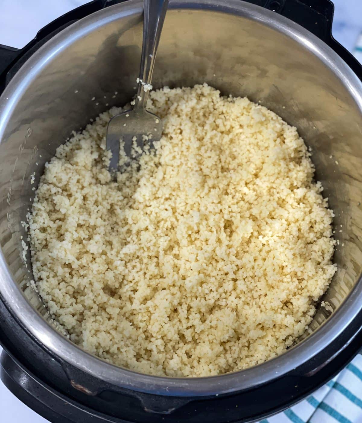 An instant pot has cooked couscous.