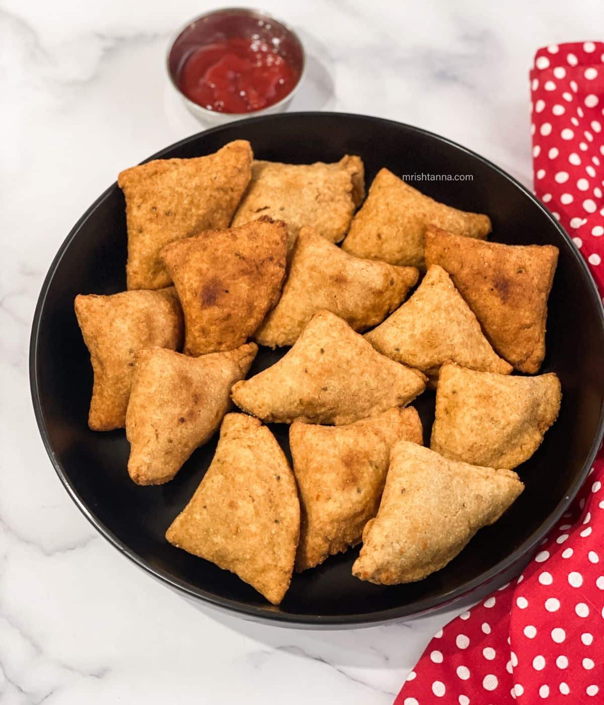 A plate full of gluten free samosas.